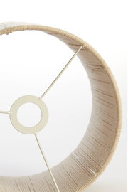 Nahaufnahme eines beigen Lampenschirms mit sichtbarer Metallstruktur von innen.