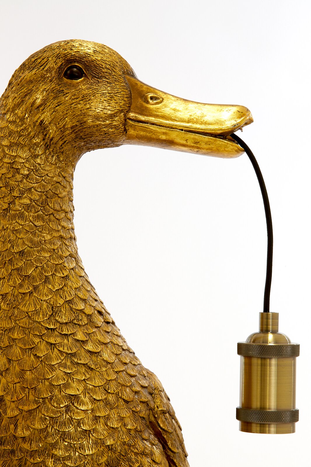Gouden tafellamp in de vorm van een eend, die een lampvoet in zijn snavel houdt, zijaanzicht.