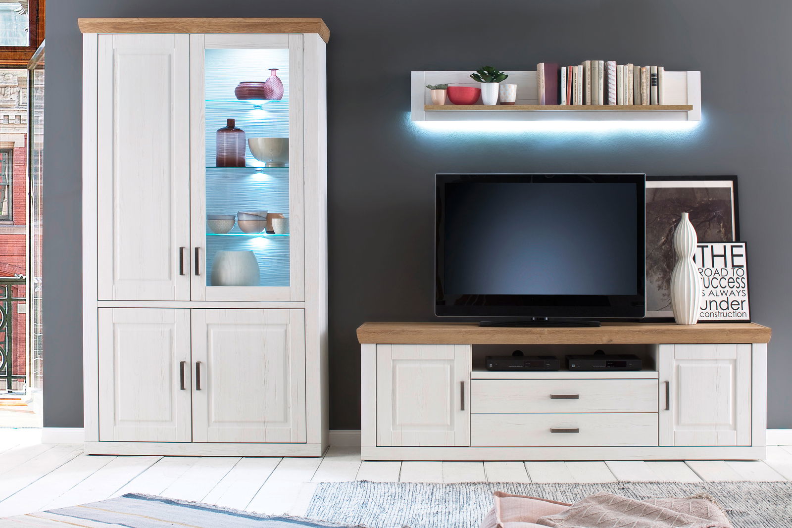 Moderne Wandkombination in heller Holzoptik mit Vitrine, TV-Schrank und Wandregal, frontal betrachtet.