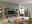 Modernes Wohnzimmer mit einem Highboard aus Holz und grauen Elementen, umgeben von stilvoller Dekoration und Pflanzen, seitliche Perspektive.