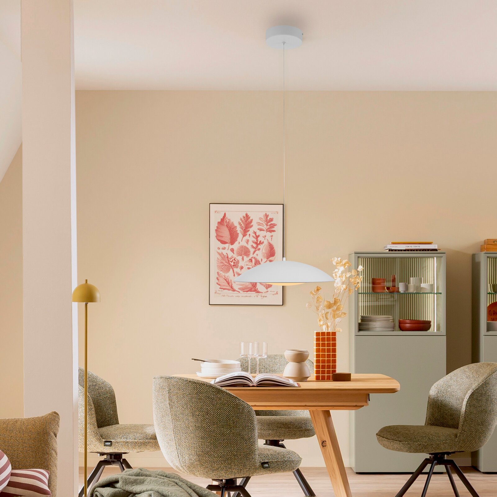 Weiße, flache Pendelleuchte mit rundem Baldachin über einem Esstisch in modernem Esszimmer, Frontansicht auf Augenhöhe