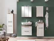 Moderner Hängeschrank in Weiß mit Holzdetails, frontal an einer grünen Wand montiert, Teil eines stilvollen Badezimmersets.