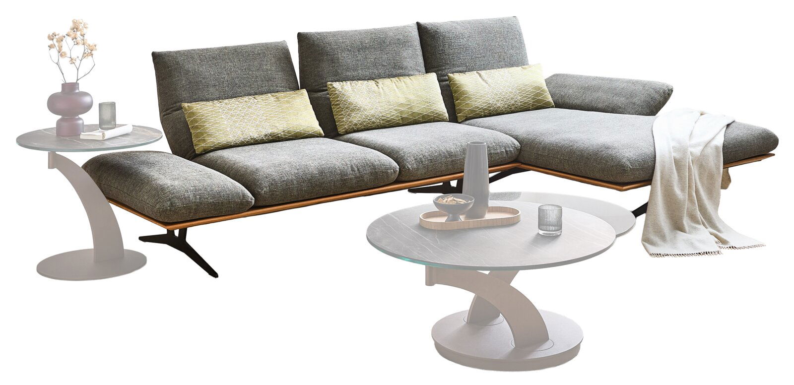 Modernes graues Ecksofa mit rechter Ottomane, drei Rückenlehnen und grünen Zierkissen, daneben runde Couchtische; Perspektive: frontale 3/4-Ansicht von leicht links vor weißem Hintergrund.
