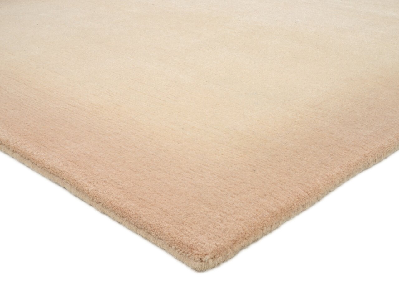 Wollteppich in sanften Beige- und Rosatönen, perspektivisch von der Ecke aufgenommen
