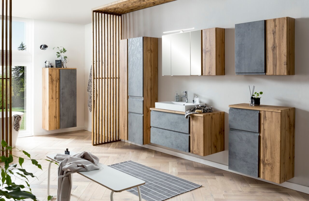 Moderner Hochschrank in Holzoptik mit grauen Akzenten, Teil eines stilvollen Badezimmersets, aus seitlicher Perspektive fotografiert.