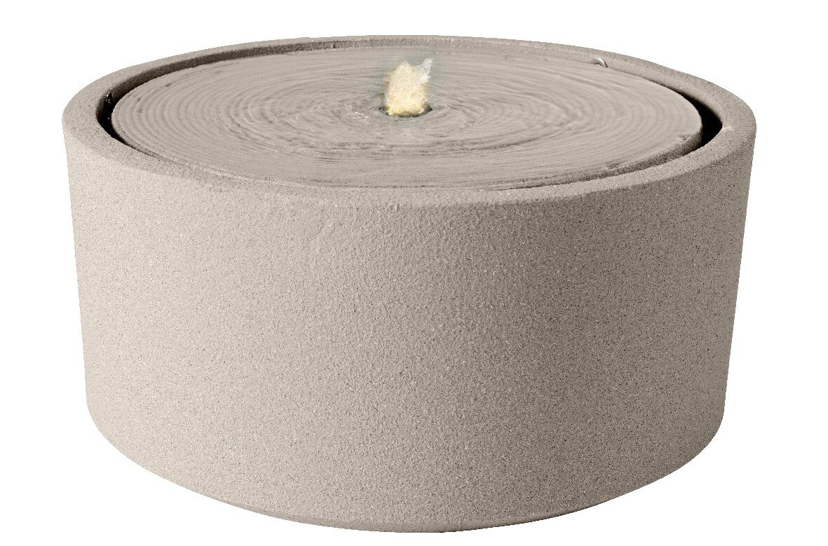 Runder, sandfarbener Brunnen aus Steinmaterial mit sprudelndem Wasser in der Mitte, seitliche Perspektive