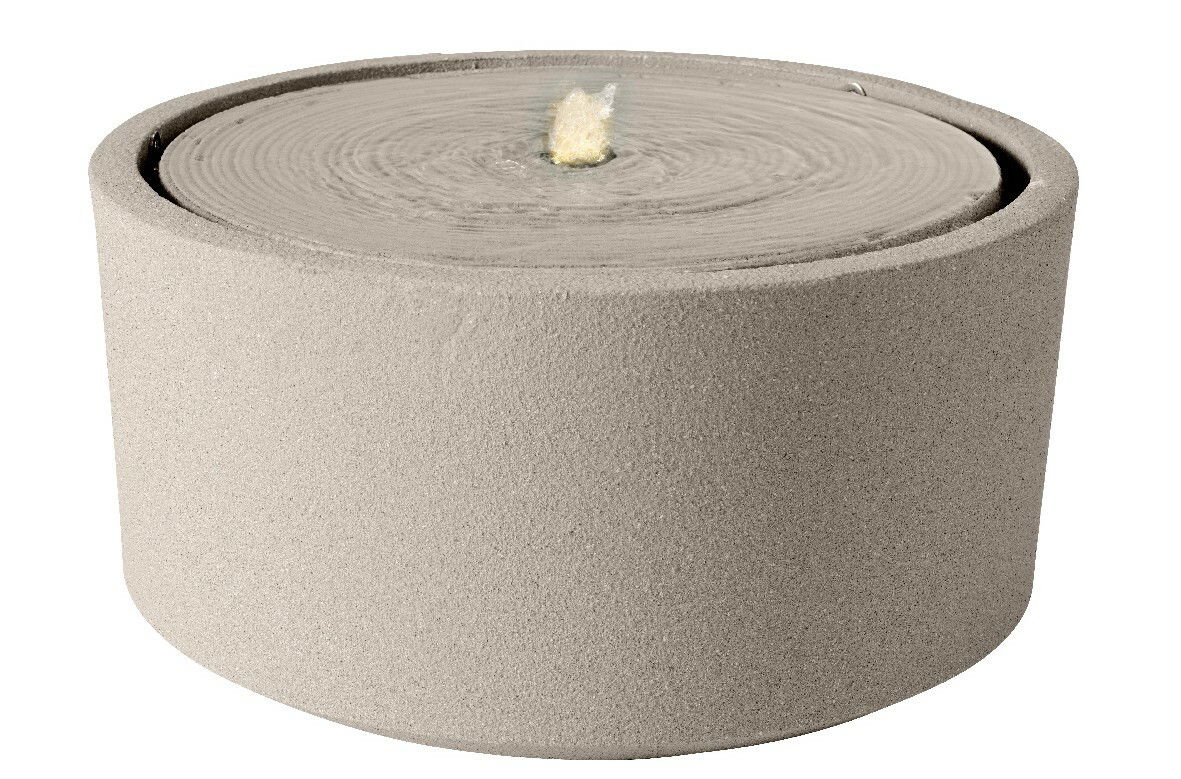 Runder, sandfarbener Brunnen aus Steinmaterial mit sprudelndem Wasser in der Mitte, seitliche Perspektive