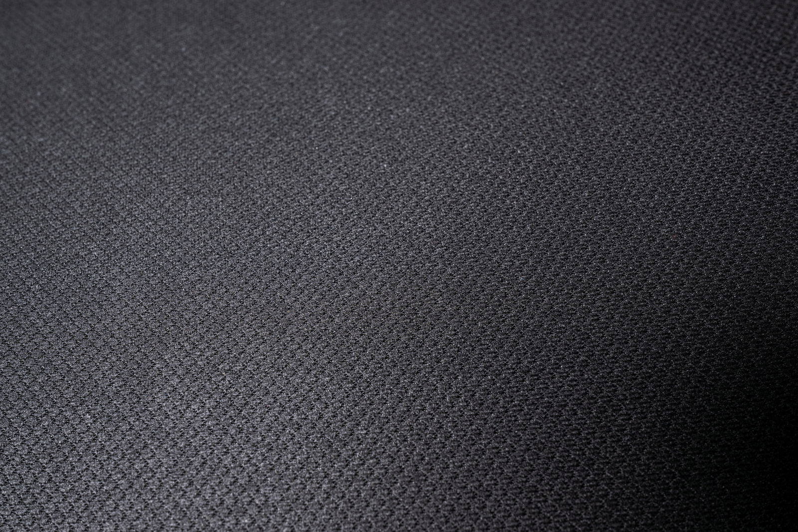 Nahaufnahme eines schwarzen Stoffbezugs mit feiner Textur, von oben betrachtet.