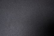 Nahaufnahme eines schwarzen Stoffbezugs mit feiner Textur, von oben betrachtet.