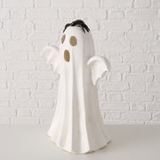 Weiße Halloween-Geisterfigur mit ausgebreiteten Armen und schwarzer Spinne auf dem Kopf vor weißer Ziegelwand, frontal in leichter Untersicht fotografiert