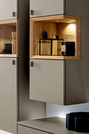 Detailansicht der Venjakob Wandkombination ANDIAMO 3.0 mit beleuchtetem Holzregal und modernen Dekorationsobjekten.