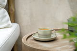 Espressotasse mit Untertasse auf einem Holztisch, seitliche Perspektive