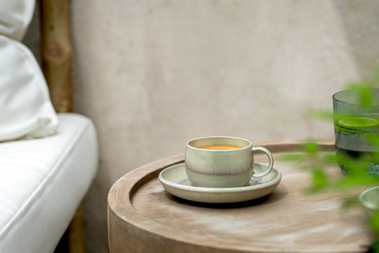 Espressotasse mit Untertasse auf einem Holztisch, seitliche Perspektive