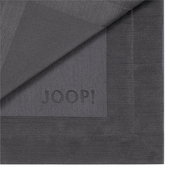 Graphitfarbene Serviette mit eingeprägtem 'JOOP!' Logo, Nahaufnahme der Ecke mit umgeschlagener Kante.