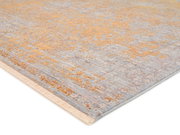 Designer Teppich in Beige- und Grautönen mit abstraktem Muster, perspektivisch von der Seite aufgenommen.