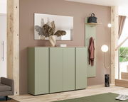 Moderner XXL-Schuhschrank in einem Flur, aus einer frontalen Perspektive fotografiert. Der Schrank hat eine grüne Farbe und steht neben einer Garderobe mit Spiegel und einer Stehlampe.