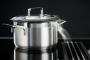 Edelstahlkochtopf mit Glasdeckel und Dampf, seitliche Perspektive