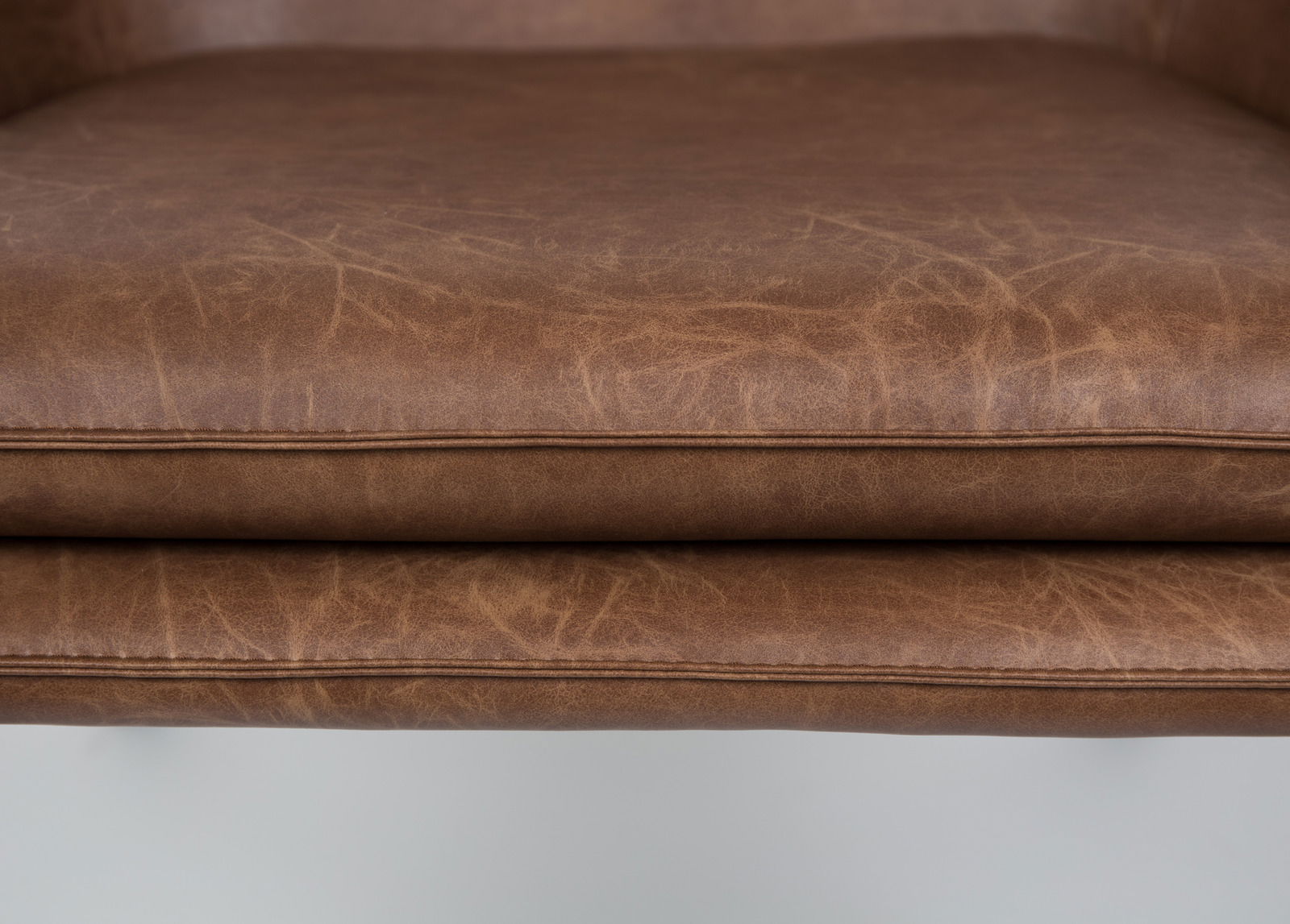 Nahaufnahme eines braunen Ledersesselsitzes von vorne