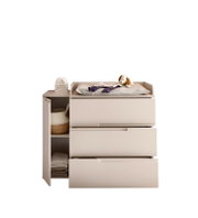 Wickelkommode in Beige mit drei Schubladen und offenem Seitenregal, oben Wickelauflage mit Stofftier; Frontansicht leicht von links auf weißem Hintergrund