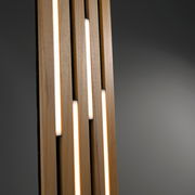 Nahaufnahme einer modernen LED-Tischleuchte mit vertikalen Holzstreifen und integrierten Leuchtstreifen, seitliche Perspektive.