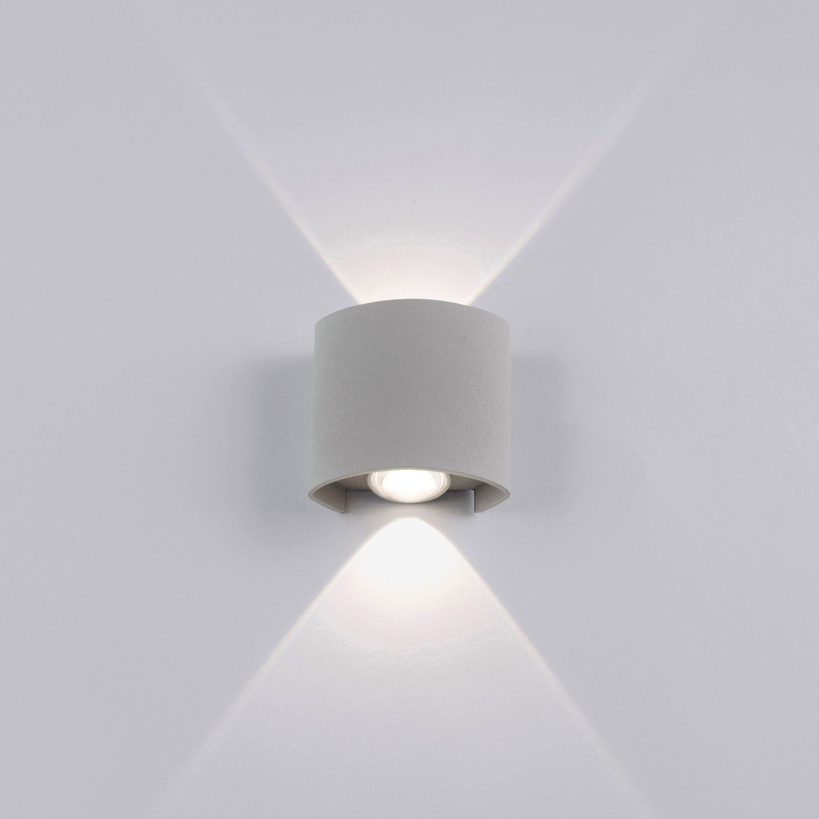 Silberne Wandleuchte CARLO mit zylindrischem Design, die Licht nach oben und unten abstrahlt, frontale Perspektive.