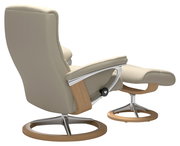 Beiger Einzelsessel mit passendem Hocker, seitliche Perspektive