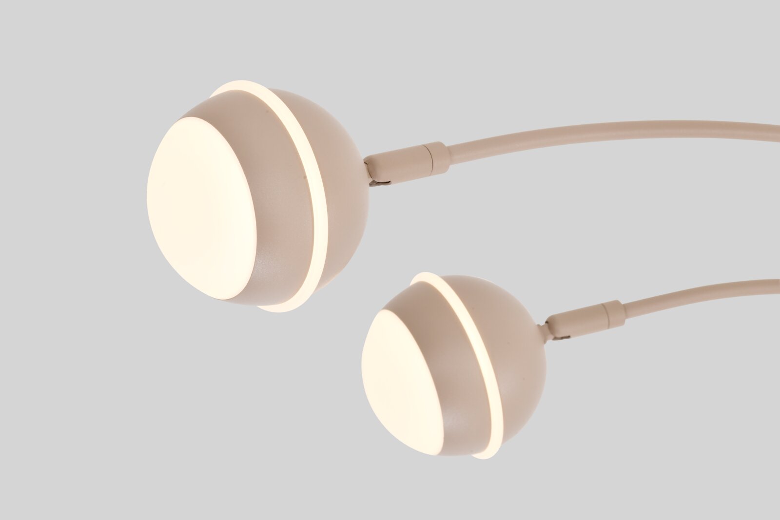 Twee ronde beige LED-lampkoppen met warmwit licht en bijpassende kabels, schuin van voren afgebeeld.