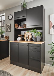 Moderner schwarzer Buffet-Schrank mit Holzarbeitsplatte, dekoriert mit Pflanzen und Küchenutensilien, aus frontaler Perspektive.