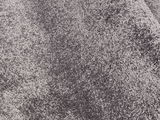 Nahaufnahme eines grauen Uni-Teppichs mit weicher Textur, perspektivisch von oben fotografiert.