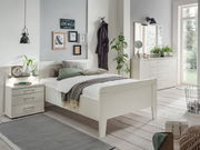 Helles Schlafzimmer mit modernem Nachtkonsolen-Paneel, seitliche Perspektive auf das Bett und die Nachttische, dekoriert mit Pflanzen und Wandbildern.