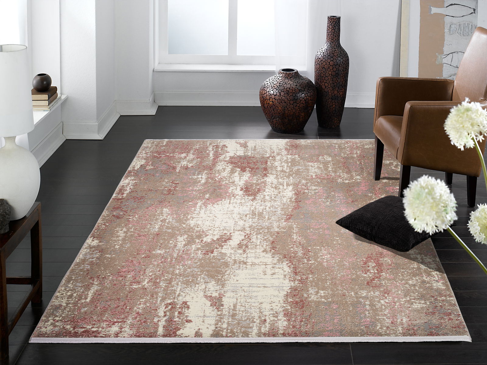 Designer Teppich in einem modernen Wohnzimmer, mit abstraktem Muster in Beige- und Rottönen, aus der Vogelperspektive fotografiert.