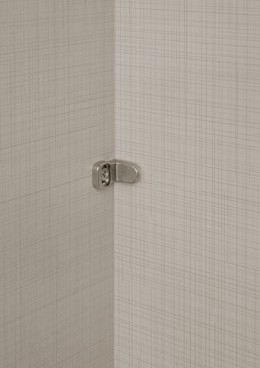 Nahaufnahme eines Scharniers in einem Schwebetürenschrank, seitliche Perspektive.