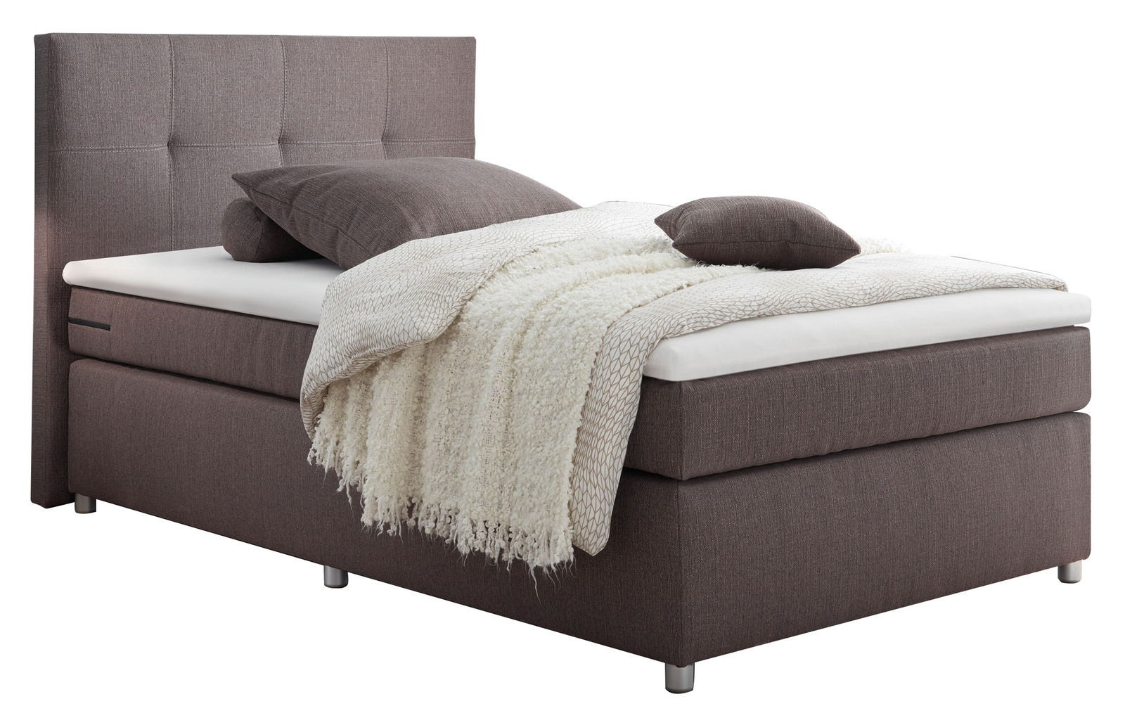 Boxspringbett in seitlicher Perspektive mit grauem Stoffbezug, Kopfteil mit quadratischer Steppung, ausgestattet mit Kissen und einer cremefarbenen Decke.