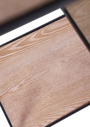 Nahaufnahme eines Holzregals mit sichtbarer Maserung und schwarzem Rahmen, von oben betrachtet.