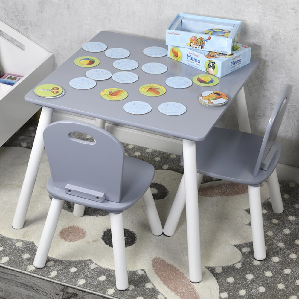 Grauer Kindertisch mit zwei Stühlen, von oben fotografiert, mit einem Memo-Spiel darauf.