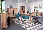 Esszimmer mit Holzmöbeln, darunter ein Esstisch, Stühle, ein Weinregal und ein Highboard, aus der Perspektive von vorne links betrachtet.