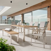 Tuinset bestaande uit een houten tafel, een houten bank en zes stoelen met metalen frame, zijaanzicht.