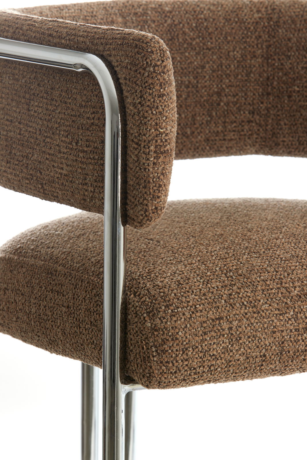 Nahaufnahme eines Armlehnstuhls mit braunem Stoffbezug und verchromtem Gestell, seitliche Perspektive.