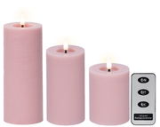 Drei rosa LED-Kerzen aus Wachs in verschiedenen Größen mit flackerndem Licht, begleitet von einer Fernbedienung. Frontalansicht.