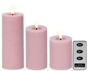 Drei rosa LED-Kerzen aus Wachs in verschiedenen Größen mit flackerndem Licht, begleitet von einer Fernbedienung. Frontalansicht.