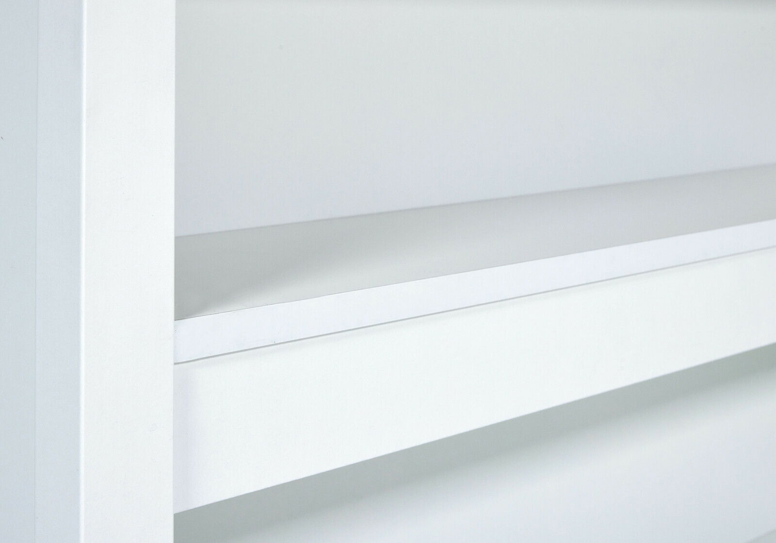 Nahaufnahme einer weißen Kücheninsel mit klaren Linien und minimalistischer Gestaltung, seitliche Perspektive.