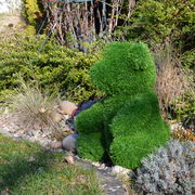Grüner Bär aus Kunstrasen, seitliche Perspektive, im Garten platziert