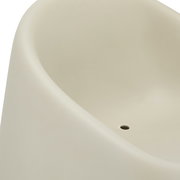 Nahaufnahme eines cremefarbenen Stapelsessels mit glatter Oberfläche und einem kleinen Loch in der Sitzfläche, von oben betrachtet.