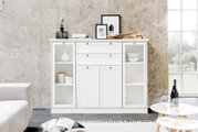 Weißes Highboard mit offenen Regalen und Schubladen, frontal fotografiert, dekoriert mit Vasen und Bildern.