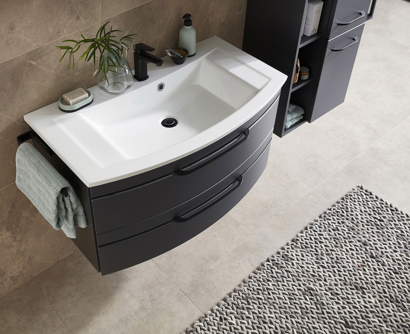 Moderne Badkombination mit Waschbecken und Unterschrank in dunklem Design, von oben betrachtet.