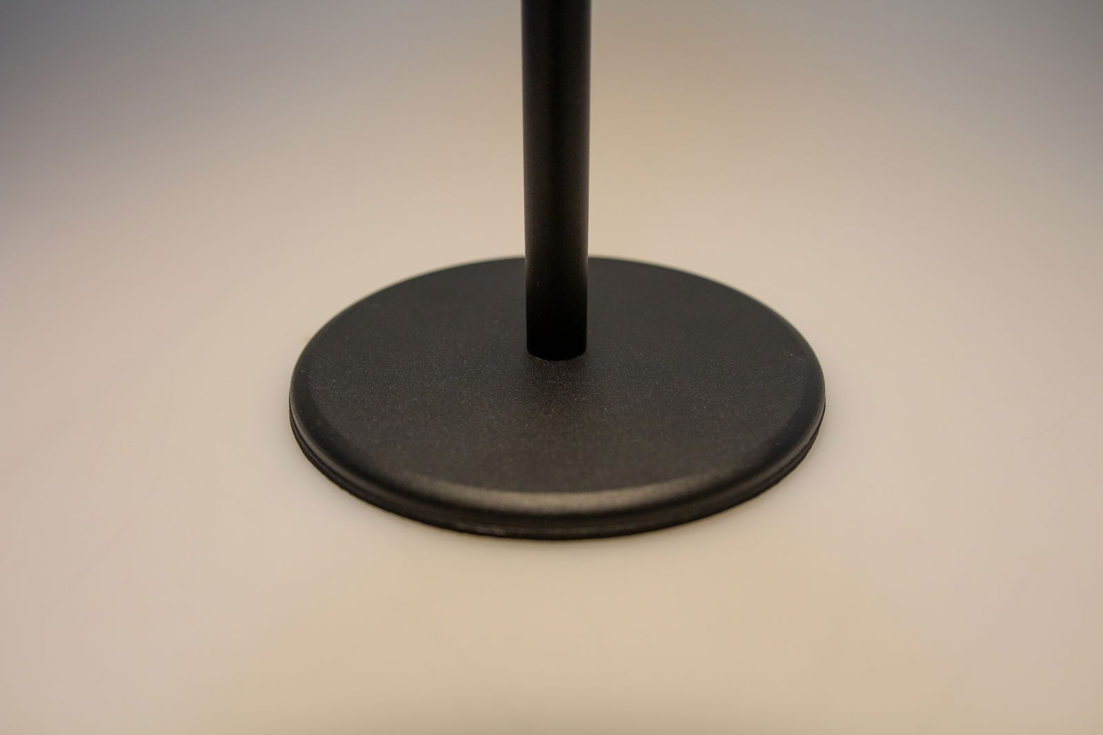 Nahaufnahme des Sockels einer schwarzen Akku-Tischleuchte aus seitlicher Perspektive.