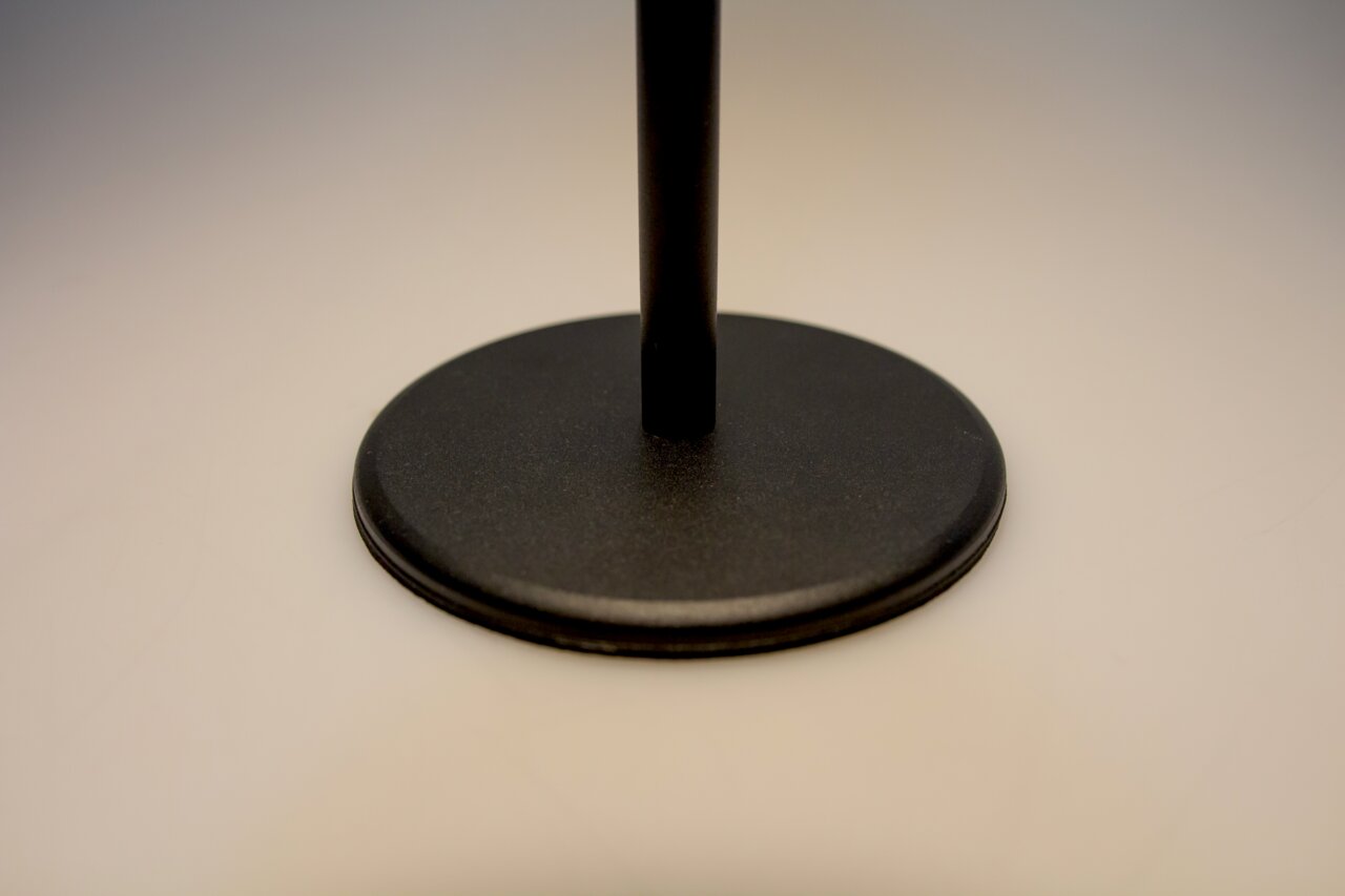 Nahaufnahme des Sockels einer schwarzen Akku-Tischleuchte aus seitlicher Perspektive.