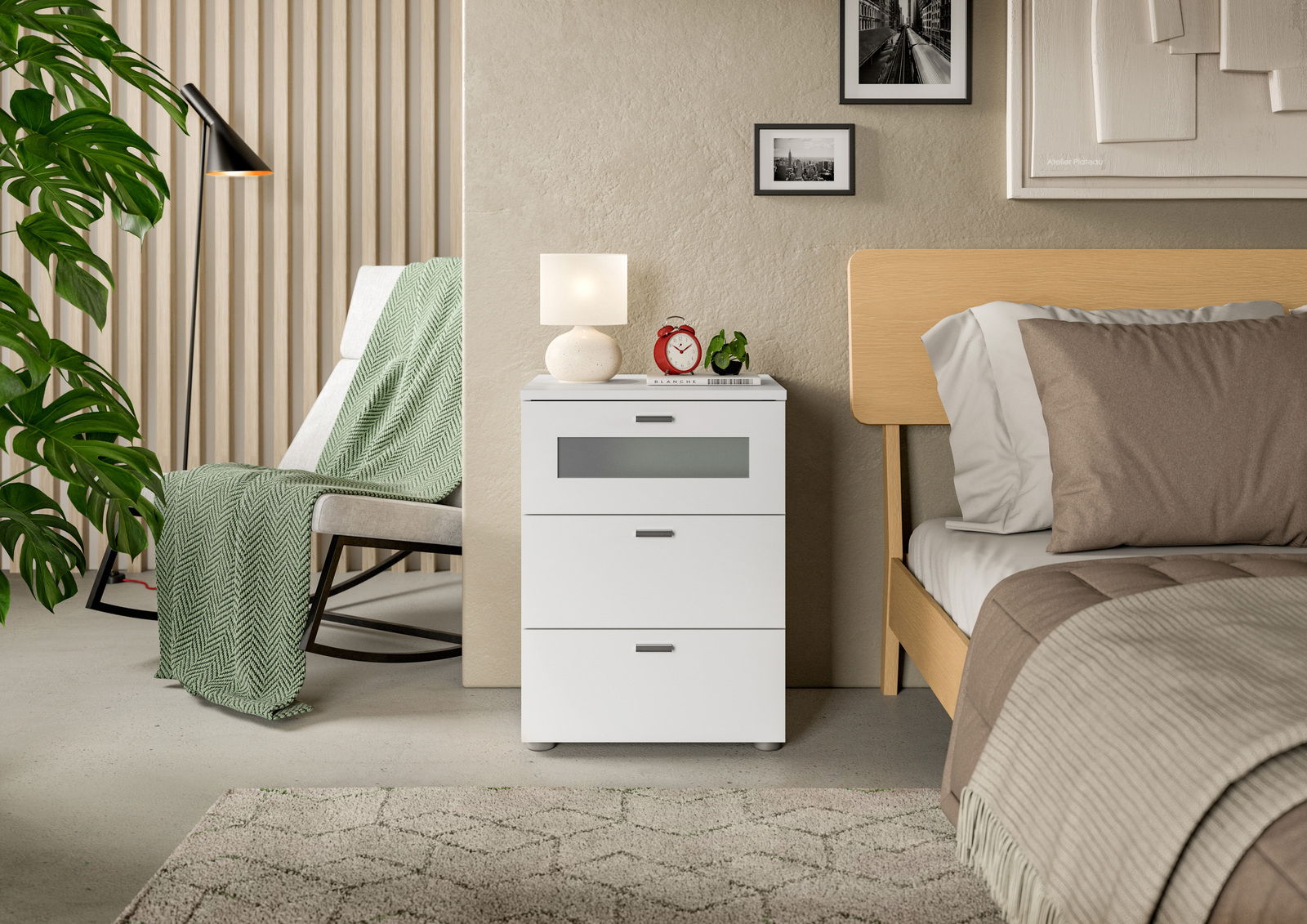 Weiße Nachtkommode mit drei Schubladen, dekoriert mit einer Lampe und einem Wecker, neben einem Bett in einem modernen Schlafzimmer, seitliche Perspektive.