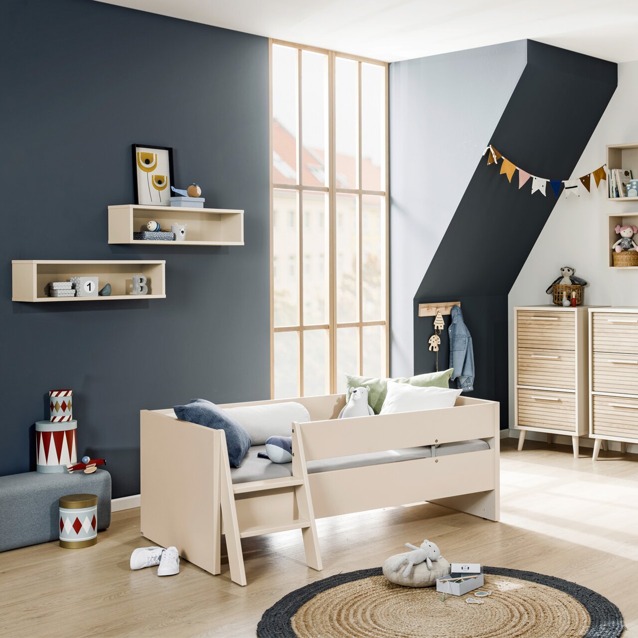 Paidi Leiter EEFJE Kinderzimmer mit einem beige-farbenen Kinderbett mit integrierter Leiter, umgeben von modernen Möbeln und Dekorationen. Perspektive von vorne auf das Bett.