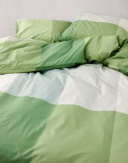 Grüne und weiße Bettwäsche mit Karomuster, aus der Vogelperspektive fotografiert.